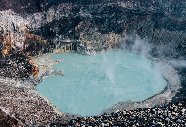 A breathtaking aerial view of a turquoise lake nestled within a volcano crater in El Salvador.