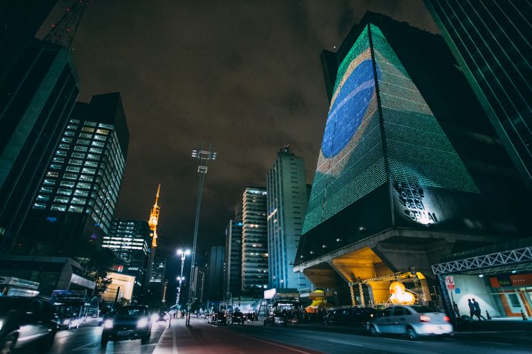A dynamic nighttime cityscape in Sao Paulo featuring modern skyscrapers and street lights.