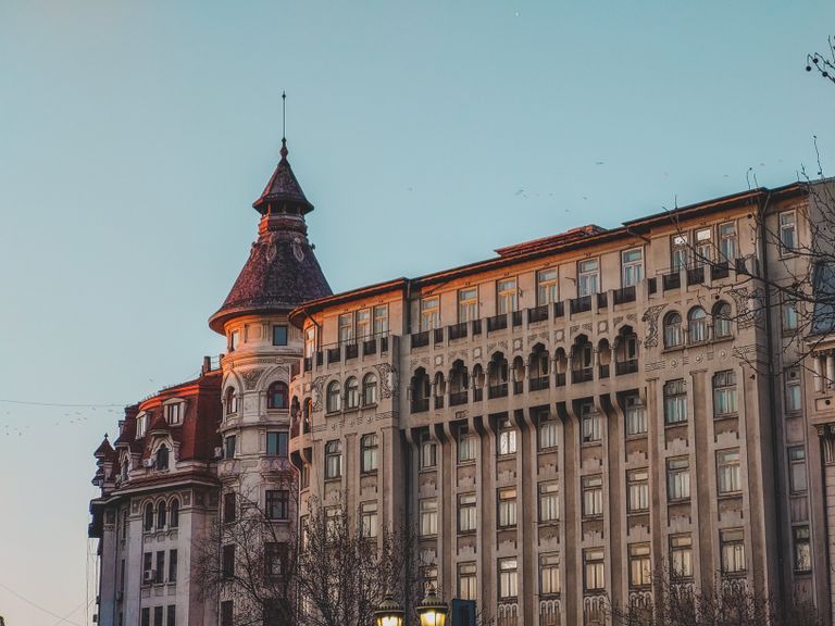Elegant historical architecture in Bucharest, Romania, showcasing intricate facade design during twilight.
