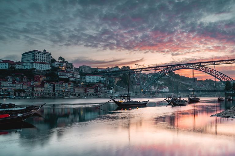 Breathtaking view of Porto's skyline and Douro River at sunset, featuring the iconic Luis I Bridge.